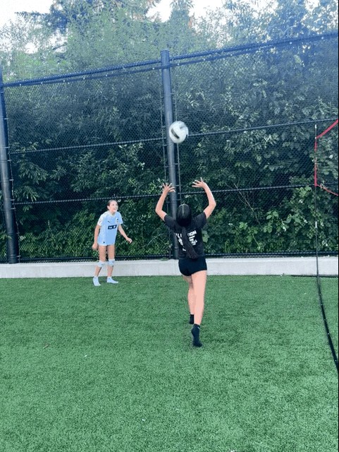 Volleyball players setting on an outdoor turf court