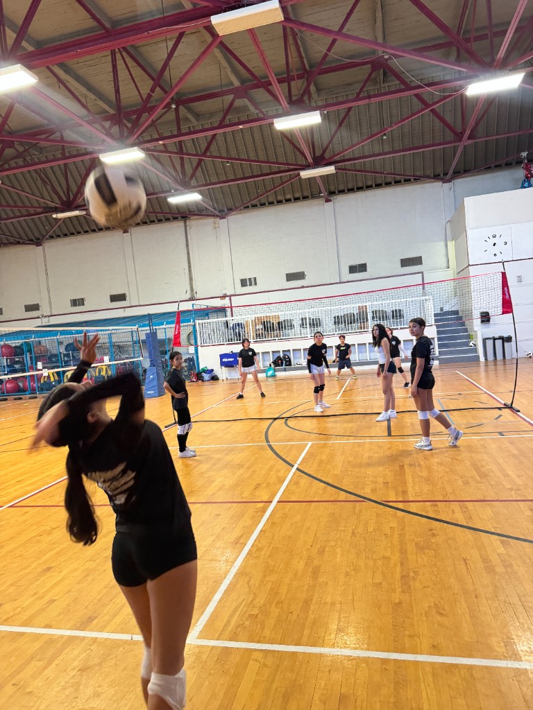 Youth volleyball serve during indoor gym training
