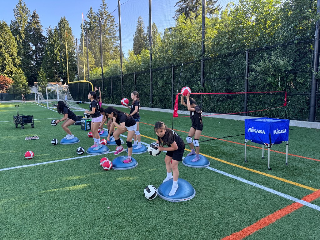 Young athletes on Bosu balls during outdoor volleyball training